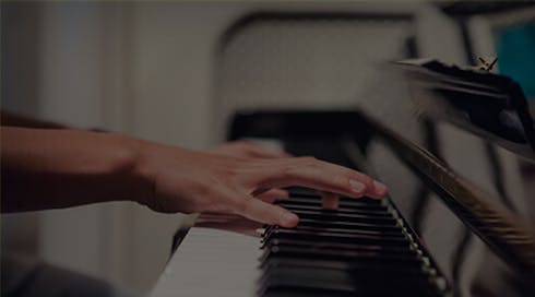 hands playing a piano